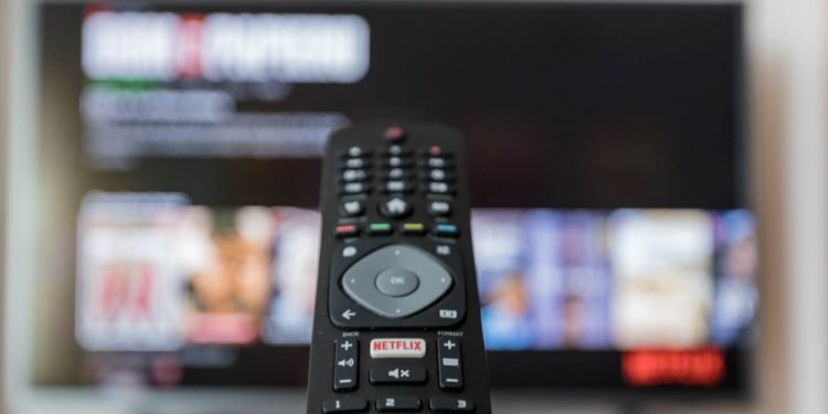 Image of Tv and a remote and Tv displaying an online platform